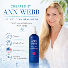 Load image into Gallery viewer, Ann Webb Liquid Moisture spray bottle in blue with a white pump, shown next to a smiling blonde woman in a white top on a bright, light blue background with product benefits listed on the left.
