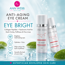 Load image into Gallery viewer, Ann Webb Anti-Aging Eye Cream Eye Bright in a white bottle with silver and red accents, displayed alongside a matching tube on a light blue water-themed background with green leaves.