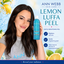 Load image into Gallery viewer, A woman holds up a bottle of Ann Webb Skin Care Lemon Luffa Peel against a bright, water-and-lemon themed background with product benefits listed on the right.