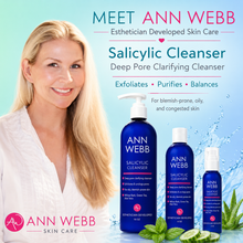 Load image into Gallery viewer, Ann Webb Salicylic Cleanser skincare set featuring three blue bottles of varying sizes with pump and spray dispensers, set against a light blue water splash background with mint leaves. A smiling blonde woman in a white robe is shown on the left side of the image with promotional text.