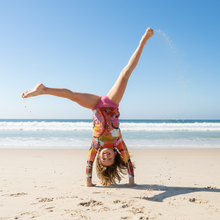 Load image into Gallery viewer, Circle in the Sand Girls Rash Guard Whimsy Fit UPF 50+ Long Sleeve Swim Shirt Beach cartwheel action shot