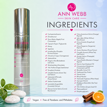 Load image into Gallery viewer, Ann Webb Skin Care Lighten Up Serum bottle on a white background with ingredient list and fruit props, including an orange slice and green leaves.