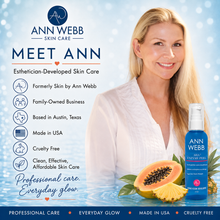 Load image into Gallery viewer, A promotional graphic for Ann Webb Skin Care featuring a smiling blonde woman on the right and a blue bottle of AHA Exfoliating Gel on the right foreground, alongside text callouts and fruit props including papaya and pineapple. The left side includes the Ann Webb logo, 'Meet Ann' branding, and product benefits.
