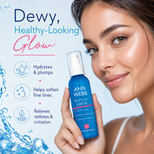 Load image into Gallery viewer, A woman holds an Ann Webb BE PLUS Serum bottle against a light blue background with promotional text and water graphics. The bottle is bright blue with a white pump and clear cap.
