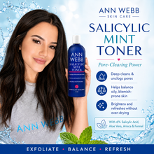 Load image into Gallery viewer, A woman holds a bottle of Ann Webb Salicylic Mint Toner against a bright blue water-themed background with product text and benefits. The bottle is dark blue with white text and a white cap.
